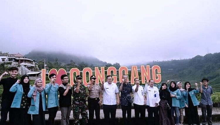 Bupati Magetan Suprawoto berpose di gerbang desa Gonggang. (Foto: Istimewa)