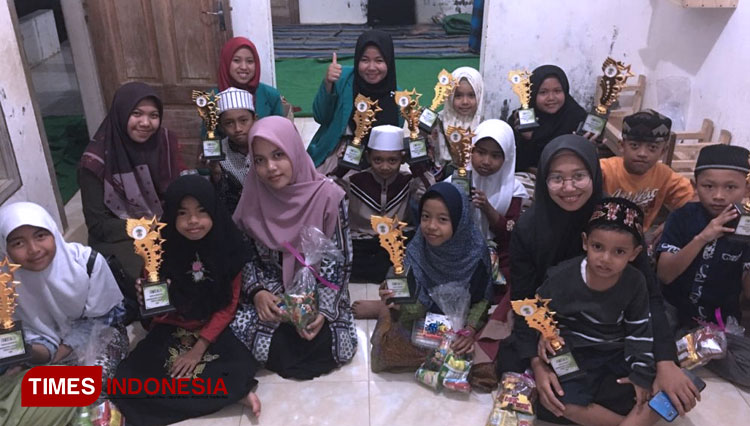 Foto bersama anak-anak TPQ dengan menunjukkan piala hadiah lomba. (FOTO: AJP/TIMES Indonesia)
