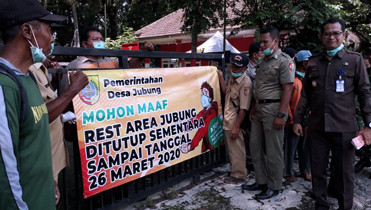 Petugas membentangkan spanduk penutupan area peristirahatan Jubung, Selasa (24/3/2020). (Foto: Istimewa)