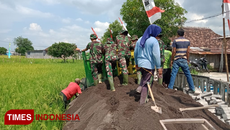 Prajurit TNI saat membangun jalan poros desa (Foto: Satgas Penerangan TMMD Kodim 0817/Gresik).