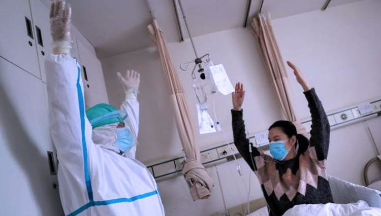 Ilustrasi - Petugas medis memberi terapi untuk pasien Covid-19 di sebuah rumah sakit di Wuhan (FOTO: Reuters)