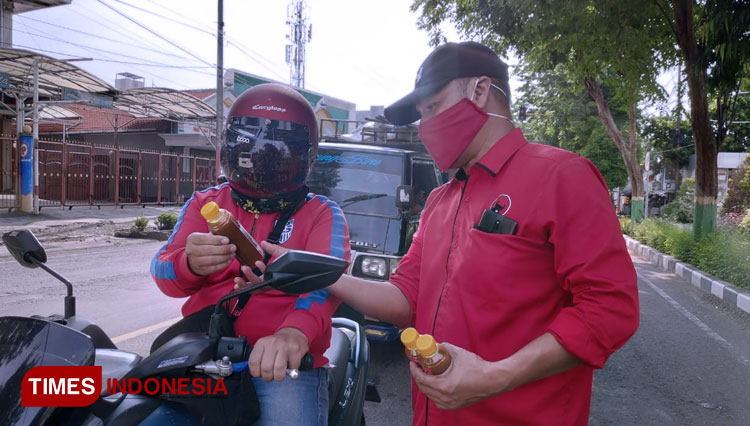 Kader DPC PDI Perjuangan Tuban saat membagikan jamu kepada masyarakat, Kamis, (26/03/2020). (Foto: Achmad Choirudin/TIMES Indonesia)