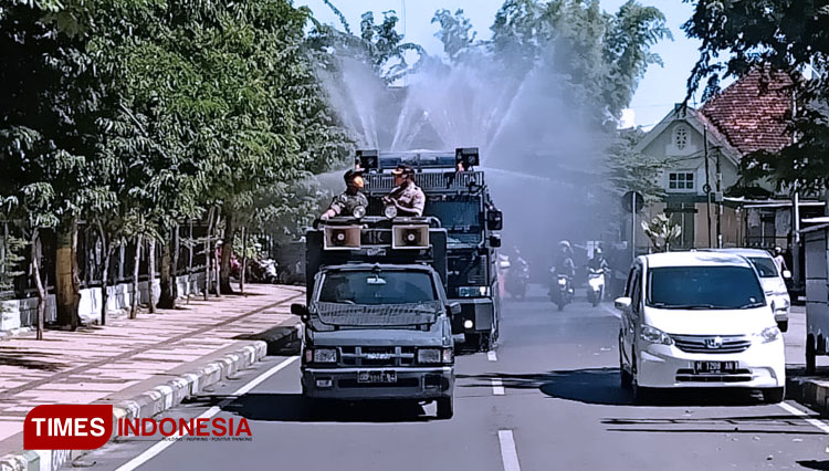 Penyemprotan cairan disinfektan menggunakan mobil water canon di jalan Raya Pameksan. (Foto: Akhmad Syafi'i/TIMES Indonesia)