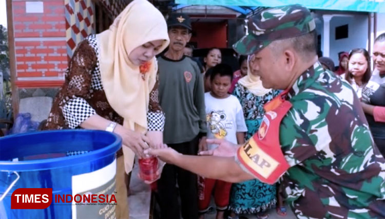 Pelda Asmuni, Kepala Kesehatan Satgas TMMD Reguler Pekalongan melatihkan cara mencuci tangan yang baik dan benar dengan cairan desinfektan. (FOTO: AJP/TIMES Indonesia)
