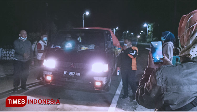 Beberapa petugas di posko Kedungbanteng Ponorogo mengimbau kendaraan pedagang sayur dari Magetan untuk kembali. (FOTO: Marhaban/TIMES Ponorogo)