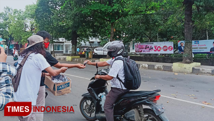 Para Seniman Sablon Indramayu membagikan masker gratis di Jl Protokol Indramayu. (Siti Raudiatul Nadiyah/TIMES Indonesia)