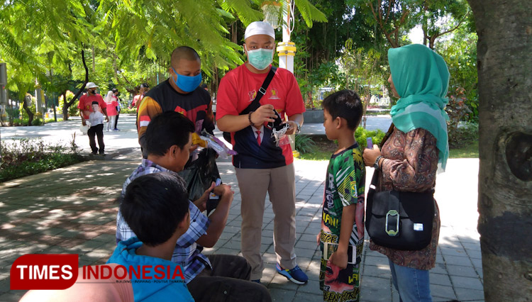 Ketua DPC Gerindra Gresik dr Asluchul Alif Maslichan bersama kadernya saat membagikan seribu masker dan hand sanitizer (Foto: Akmal/TIMES Indonesia).