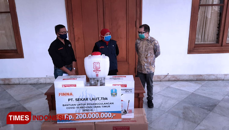 Direktur Pemasaran PT Sekar Laut Welly Gunawan menyerahkan bantuan uang tunai dan sprayer disinfektan kepada Gubernur Jawa Timur Khofifah di Gedung Negara Grahadi, Sabtu (11/4/2020). (Foto: Lely Yuana/TIMES Indonesia)