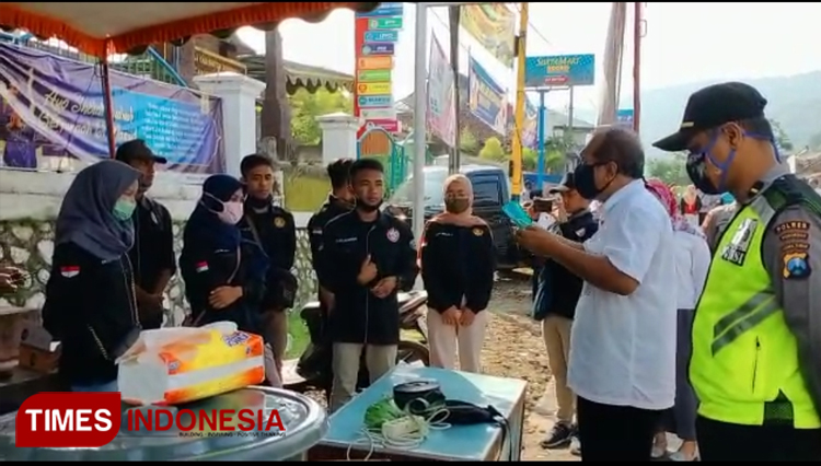Camat Sooko Kusni bersama relawan lakukan sosialisasi dan bagi-bagi masker. (foto:Heni/Times Indonesia)