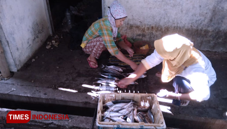 Ibu-ibu sedang bekerja menata ikan di pengasapan ikan Desa Prampelan Kecamatan Sayung Demak. Senin 27/4/2020. (FOTO: Fuhatur Rohman/ TIMES Indonesia)