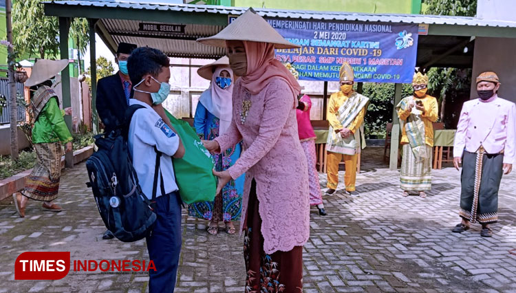 Kepala SMPN 1 Magetan, Titik Sudarti saat menyerahkan paket sembako kepada siswa. (FOTO: Aditya Candra/TIMES Indonesia).