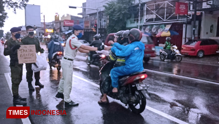 Pembagian takjil kepada pengendara motor. (FOTO: AJP TIMES Indonesia)