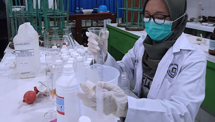 Pekerja laboratorium sedang menakar reagen sebagai bahan utama pembuatan handsanitizer. (foto: Humas Udinus)