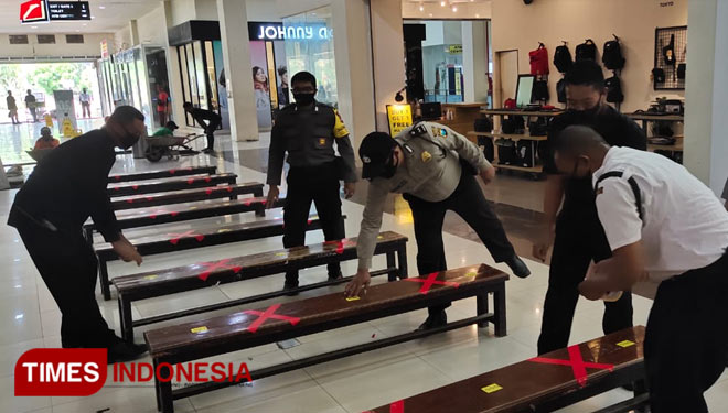 Anggota polisi menertibkan keramaian di Roxy Square Jember dan memasang tanda pembatas di tempat duduk pengunjung. (Foto: Polsek Kaliwates for TIMES Indonesia)