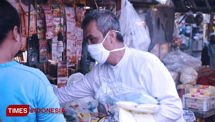 Petugas membagikan masker di Pasar Palur Karanganyar. (FOTO: Humas Pemkab Karanganyar/TIMES Indonesia)