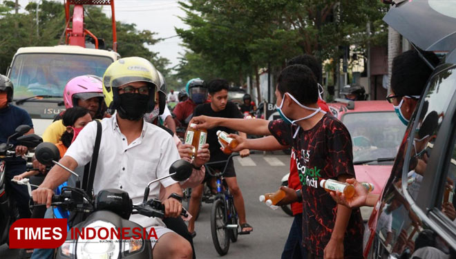 Relawan kolaborasi Ademos dan Kelas Kewirausahaan Sosial UGM ketika membagikan masker dan takjil di Bojonegoro. (FOTO: Ademos for TIMES Indonesia)