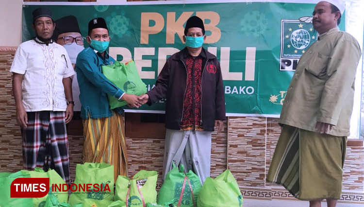 Anggota F-PKB DPRD Kabupaten Bondowoso, H Syamsul Tahar (jaket hijau), saat menyerahkan paket sembko secara simbolis (FOTO: Moh Bahri/TIMES Indonesia)