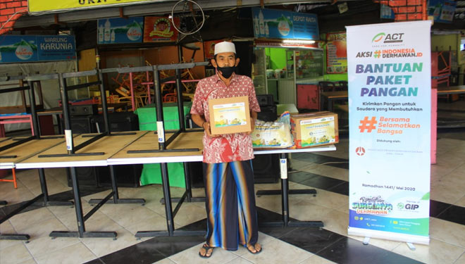 Adi Mulyono, pedagang kali lima di Sentra Wisata Kuliner Urip Sumoharjo, menerima bantuan paket pangan Ramadan ACT Jatim, Sabtu (23/5/2020).(Foto : Dok.ACT) 