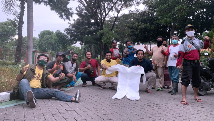 Perwakilan Komunitas Bergerak dari Rumah memberikan bantuan baju hazmat kepada petugas pemakaman TPU Keputih Surabaya. (FOTO: Dok. Komunitas) 