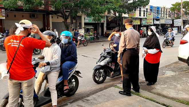 Perawat khusus pasien corona RSWN Semarang sedang turun jalan membagikan masker dikawal oleh anggota Polsek Tembalang Kota Semarang. (humas RSWN)
