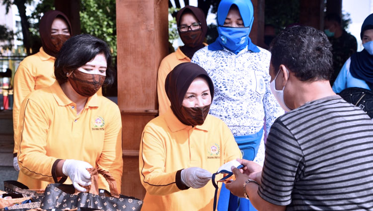 Anggota Dharma Pertiwi Daerah E membagikan bingkisan dan vitamin kepada warga usai mengikuti rapid tes massal di Lapangan Kodam Brawijaya, Rabu (27/5/2020). (Foto : Dok.Pendam V/Brawijaya) 