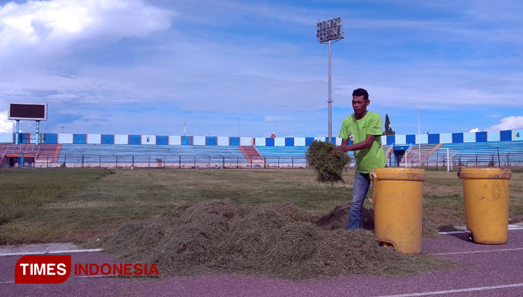 Pekerja membersihkan potongan rumput Stadion Surajaya Lamongan, Sabtu (30/5/2020). (MFA Rohmatillah/ TIMES Indonesia)