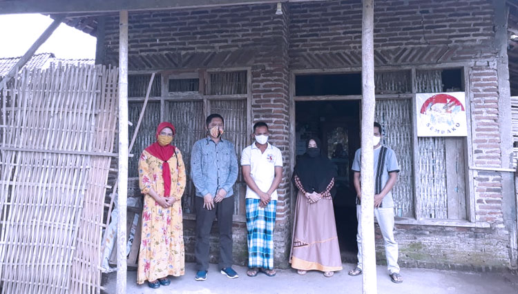 Yuli Astutik, salah satu warga Desa Bimo, Kabupaten Probolinggo yang mengembalikan BLT Dana Desa, berfoto di depan rumahnya bersama perangkat desa setempat (foto: perangkat Desa Bimo)