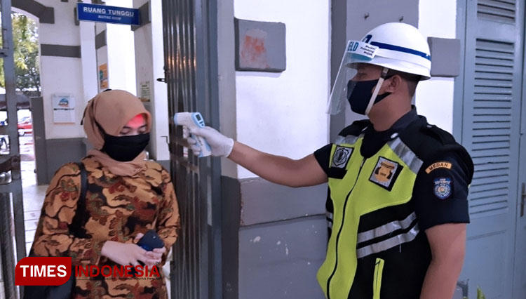 Seorang petugas sedang melakukan pengecekan suhu badan calon penumpang kereta api. (FOTO: PT KAI for TIMES Indonesia)