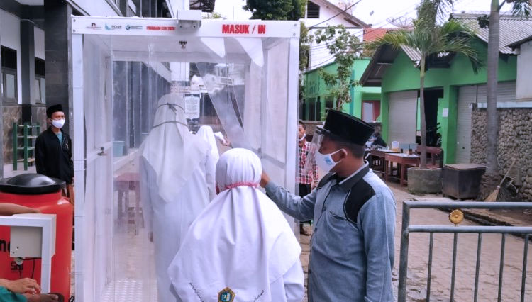 Santri Ponpes Zainul Hasan Genggong melewati bilik sterilisasi, sebelum masuk asrama pondok. (foto: Gus Ahmad Syamsul Askandar for Times Indonesia)