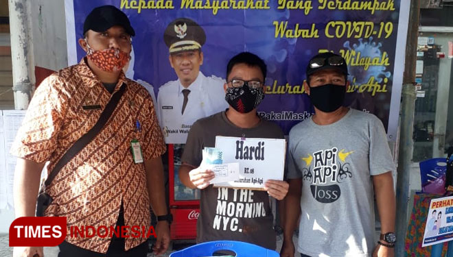 Lurah Api-Api, Andiga Mufti Kuswardani saat menyerahkan BLT. (Foto: Fajri/TIMES Indonesia)