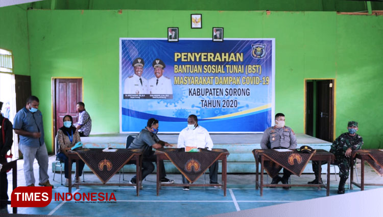 Bupati Sorong Dr. Johny Kamuru, S.H., M.Si menyerahkan Bantuan Sosial Tunai (BST) kepada warga terdampak penyebaran Covid-19. (FOTO: Humas Kab. Sorong/TIMES Indonesia)