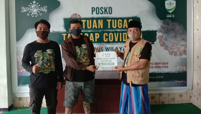 Koordinator Bonek Suroboyo M Rizal menyerahkan donasi kepada Moch Rofi’i Boenawi Sekretaris NU Care Lazisnu Jawa Timur, Jumat (5/6/2020).(Foto : Lazisnu Jatim) 