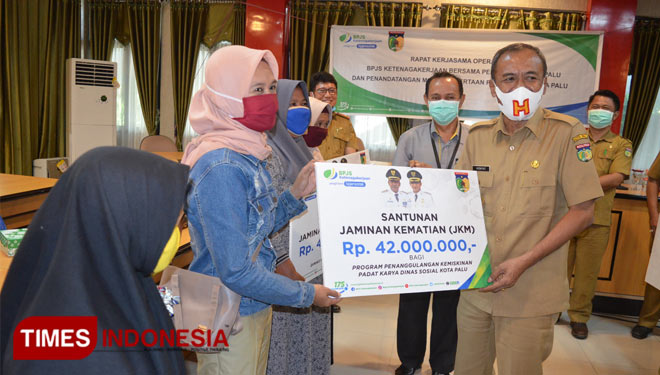 Wali Kota Palu Hidayat menyerahkan secara simbolis santunan JKM kepada anggota padat karya. (Foto: Humas Pemkot Palu for TIMES Indonesia)