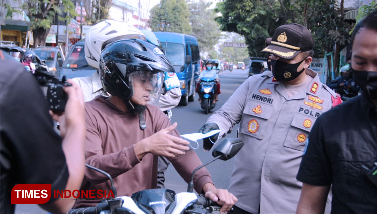 Kapolres Malang, AKBP Hendri Umar saat membagikan masker kepada penggunaan jalan. (FOTO: Hunas Polres Malang/TIMES Indonesia)