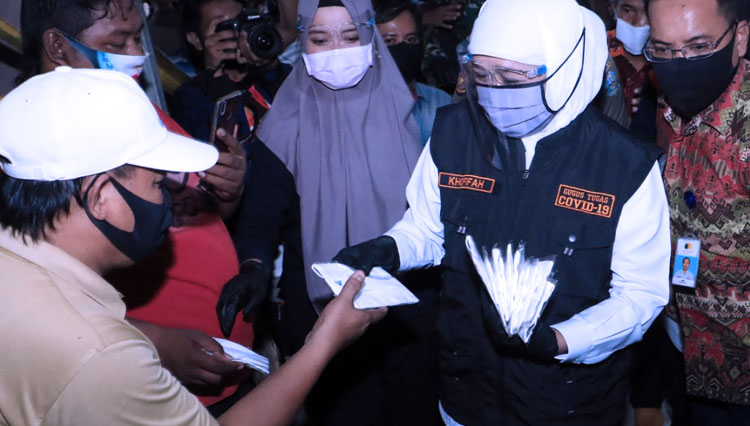 Gubernur Jawa Timur Khofifah Indar Parawansa saat membagikan masker kain kepada warga di Pasar Kapasan, Surabaya, Senin (29/6/2020). (Foto: Dok. Pemprov Jatim) 