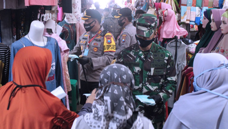 Kapolres Bangkalan AKBP Rama Samtama Putra bersama Dandim 0829 Letkol Kav Ari Setyawan Wibowo membagikan masker kepada pengunjung dan pedagang Pasar Ki Lemah Duwur. (FOTO: Humas Polres Bangkalan)