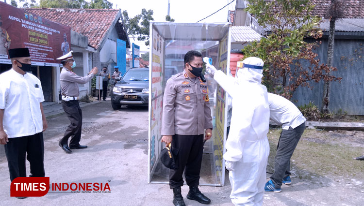 Kapolres Bangkalan AKBP Rama Samtama Putra menjalani pemeriksaan suhu badan saat berkunjung ke Asrama Polisi Tangguh. (FOTO: Doni Heriyanto/TIMES Indonesia)