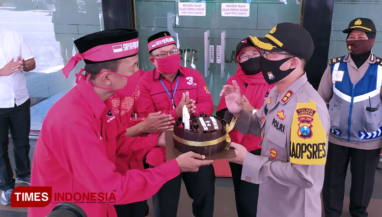 Ketua DPC PDI Perjuangan Lamongan, Saim, memberikan kue tart HUT Bhayangkara ke-74 kepada Kapolres Lamongan, AKBP Harun, di Mapolres Lamongan, Selasa (30/6/2020). (FOTO: MFA Rohmatillah/ TIMES Indonesia)