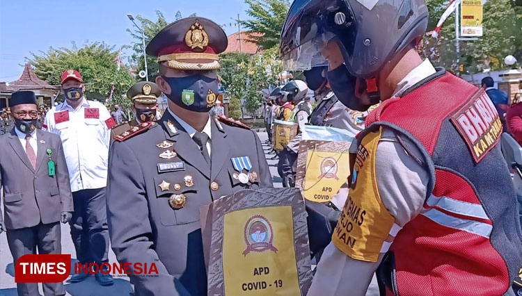 Kapolres Madiun Kota AKBP Raden Bobby Aria Prakasa menyerahkan APD kepada pengendara Motor Tangguh Semeru. (FOTO: Aditya Candra/TIMESndonesia).