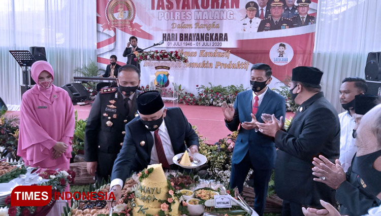 Bupati Malang, Drs HM Sanusi MM saat memberikan hadiah tumpeng kepada Kapolres Malang AKBP Hendri Umar. (Foto : Binar Gumilang / TIMES Indonesia)