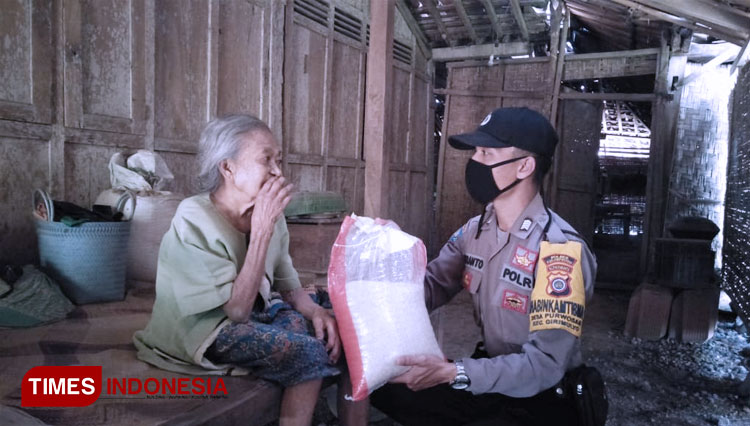 Anggota Bhabinkamtibmas Polsek Girimulyo Polres Kulon Progo, DIY ketika menyerahkan sembako kepada warga. (FOTO: Polres Kulonprogo for TIMES Indonesia)