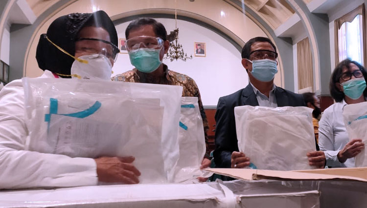 Wali Kota Risma (kiri) saat menyerahkan  bantuan APD kepada Dekan Fakultas Kedokteran Unair, Selasa (30/6/2020). (Foto: Humas Pemkot Surabaya)