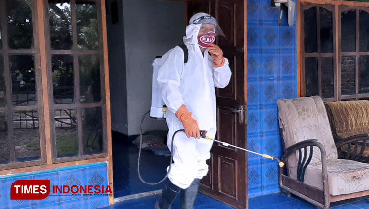 Relawan MBLC saat penyemprotan disinfektan di rumah warga Dusun Malang, Desa Brumbun, Wungu, Kabupaten Madiun, Minggu (5/7/2020). (Foto: Agus Afandi/TIMES Indonesia)