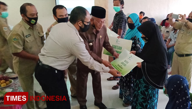 Bupati Salwa Arifin saat menyerahkan secara simbolis bantuan rumah dari AMCF (Asia Muslim Charity Foundation). Tampak bupati didampingi Sekretaris AMCF Jawa Timur, Juta Ajrullah (FOTO: Moh Bahri/TIMES Indonesia).