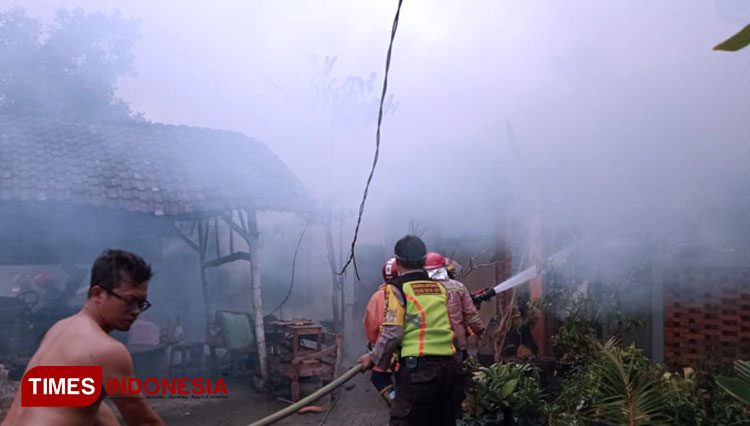 Petugas pemadam kebakaran dibantu polisi dan masyarakat berusaha memadamkan api di Gudang produksi kerajinan batok di Kelurahan Tanjungsari Kota Blitar, Senin (6/7/2020). (Foto: Sholeh/TIMES Indonesia)