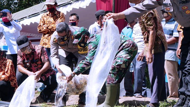 Kapolres Blitar Kota menebar benih ikan saat launching kelompok Petani Tangguh Semeru Desa Bacem Kecamatan Ponggok Kabupaten Blitar, Kamis (9/7/2020). (FOTO: Humas Polres Blitar Kota) 