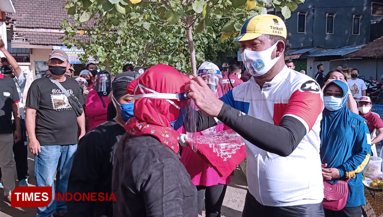 Bupati Ponorogo Ipong Muchlissoni bagikan face shield ke pedagang pasar rakyat Tonatan. (Foto: Marhaban/TIMES Indonesia)