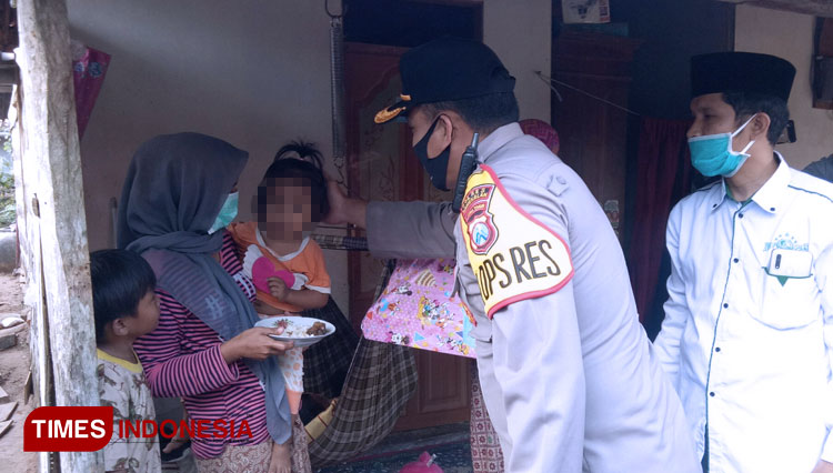 Kapolres Bangkalan AKBP Rama Samtama Putra mengelus kepala MTM putri semata wayang korban pemerkosaan almarhumah SR (21) di rumah duka Desa Bandang Laok, Kecamatan Kokop. (FOTO: Doni Heriyanto/TIMES Indonesia)