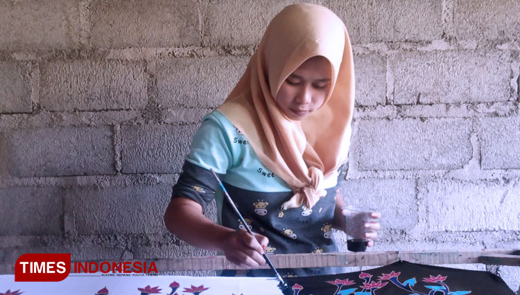 Salah satu pengrajin batik Jember tengah membatik di atas kain. (Foto: Delfi Nihayah/TIMES Indonesia)