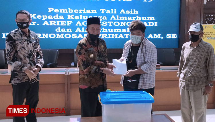 Bupati Lamongan, Fadeli, menyerahkan tali asih kepada putra almarhum dr. Arief Agoestono Hadi, Noval, di Pendopo Lokatantra Lamongan, Selasa (14/7/2020). (FOTO: MFA Rohmatillah/TIMES Indonesia)